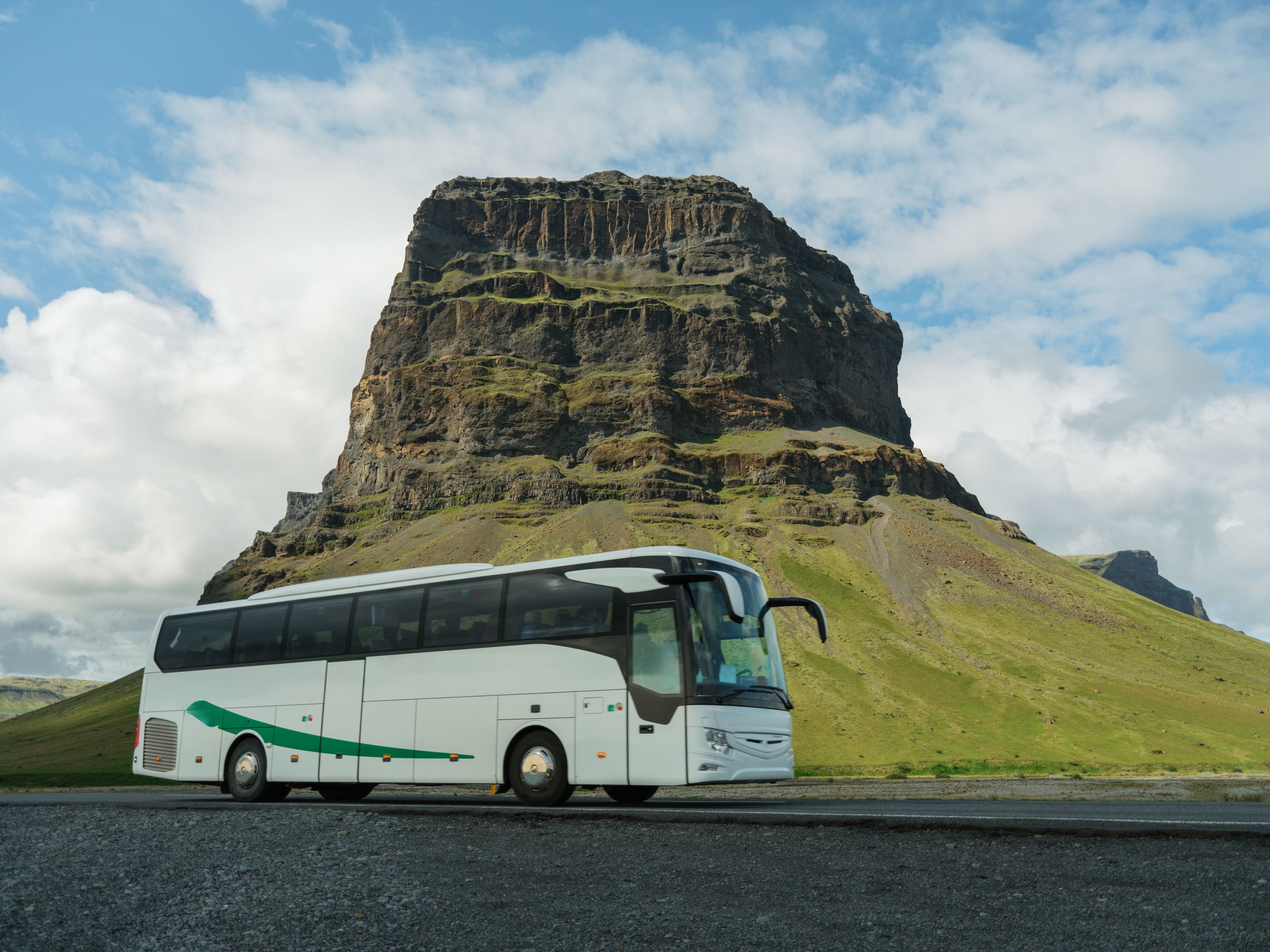 Tour bus near Kirkjufell mountain in Iceland